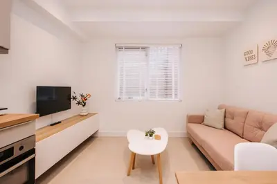 a living room with a couch and a tv at Simply studio's in Zandvoort