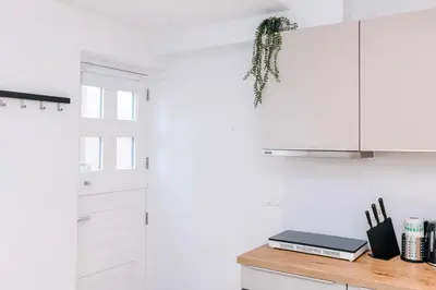 a kitchen with white cabinets and a wooden counter at Simply studio's in Zandvoort