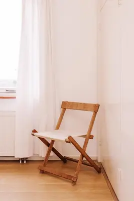 a wooden chair sitting in a room with a window at Villa Zuidwest 6, Garden, Dunes & Free parking in Zandvoort