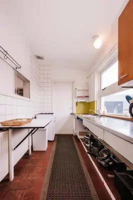 a large kitchen with white appliances and a window at Villa Zuidwest 6, Garden, Dunes & Free parking in Zandvoort