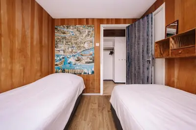 two beds in a room with a map on the wall at Villa Zuidwest 6, Garden, Dunes & Free parking in Zandvoort