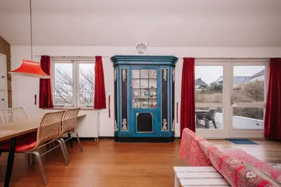 a living room with a table and a blue cabinet at Villa Zuidwest 6, Garden, Dunes & Free parking in Zandvoort