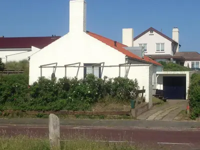 a white church with a white roof and a building at Villa Zuidwest 6, Garden, Dunes & Free parking in Zandvoort