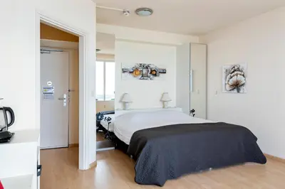 a bedroom with a large bed in a white room at Seaside in Zandvoort