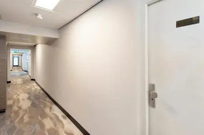 an empty hallway with a white wall and a door at Seaside in Zandvoort