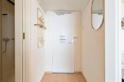 a hallway with a white door and a mirror at Seaside in Zandvoort