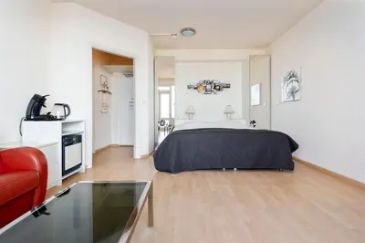 a bedroom with a bed and a red couch at Seaside in Zandvoort