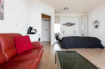 a living room with a bed and a red couch at Seaside in Zandvoort