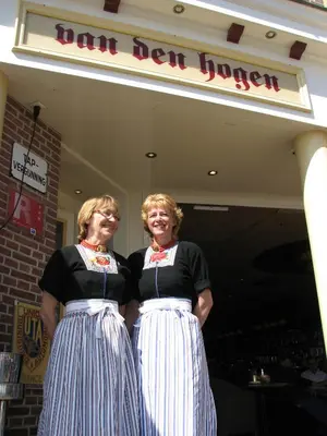 two women standing in front of a fast food restaurant at Hotel Cafe Restaurant Van Den Hogen in Volendam