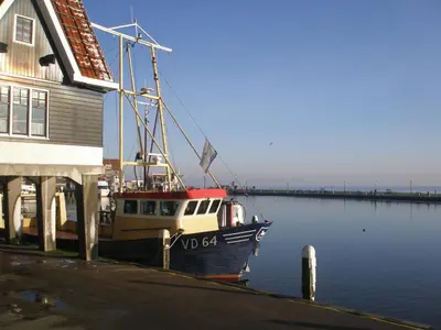 a boat is docked next to a building at Hotel Cafe Restaurant Van Den Hogen in Volendam