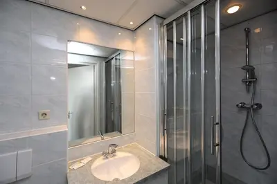 a bathroom with a sink and a shower at Hotel Cafe Restaurant Van Den Hogen in Volendam