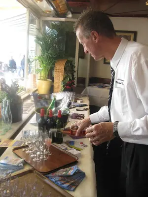 a man standing at a table with wine glasses at Hotel Cafe Restaurant Van Den Hogen in Volendam