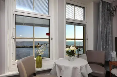 a dining room with a table and two windows at Hotel Cafe Restaurant Van Den Hogen in Volendam