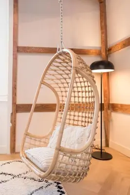 a wicker swing chair in a room with a lamp at The Prinsen in Amsterdam