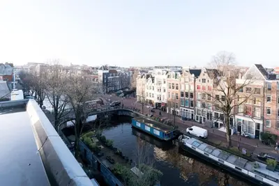 a view of a river in a city with buildings at The Prinsen in Amsterdam