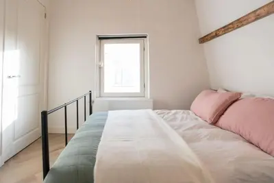 a bedroom with a bed with pink and green sheets at The Prinsen in Amsterdam