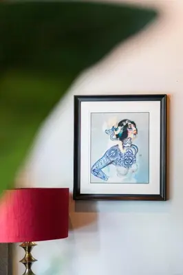 a picture of a woman on a wall with a red lamp at Weber Hotel in Amsterdam