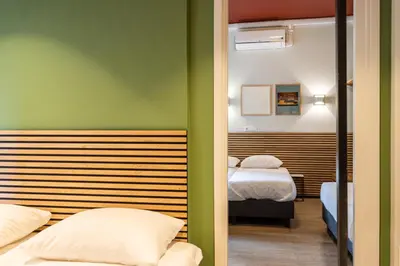 two beds in a room with green walls at Weber Hotel in Amsterdam