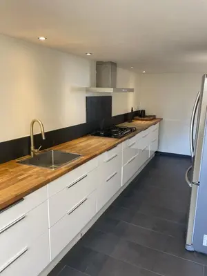 a kitchen with white cabinets and a sink at Hotel Doppenberg in Zandvoort