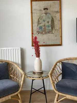 a vase on a table with two chairs and a picture at Hotel Doppenberg in Zandvoort
