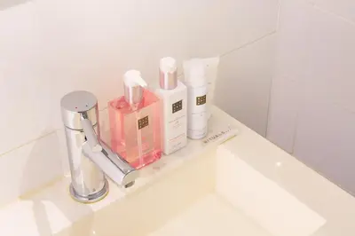 a bathroom counter with cosmetic items on a shelf at Hotel Doppenberg in Zandvoort