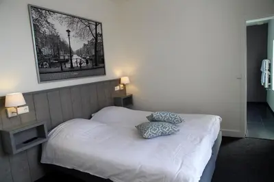 a bedroom with a bed with two pillows on it at Hotel Doppenberg in Zandvoort