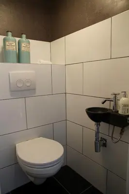 a bathroom with a toilet and a sink at Hotel Doppenberg in Zandvoort