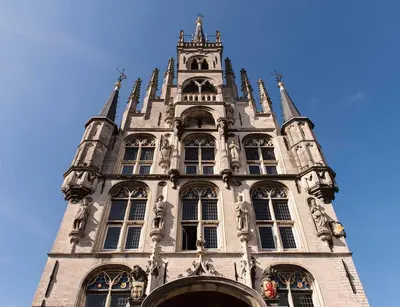 a tall building withwindows and a tower with a blue sky at Hofje van Sint Jan in Gouda