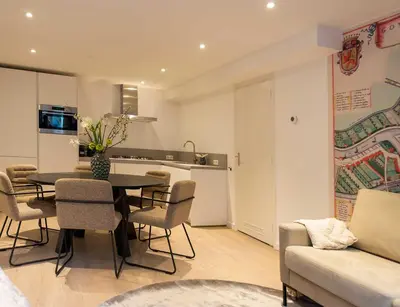 a living room with a table and chairs and a kitchen at Hofje van Sint Jan in Gouda