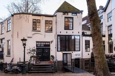 a white house with a tree in front of it at Hofje van Sint Jan in Gouda