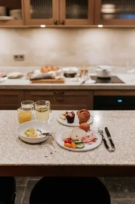 a table with plates of food and glasses of orange juice at The Times Hotel in Amsterdam