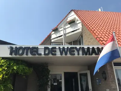 a hotel deweymann sign on a building with a flag at Hotel De Weyman in Santpoort-Noord