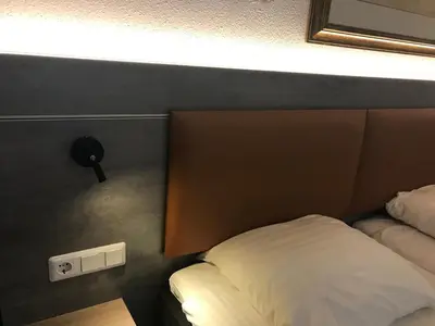 a hotel room with a bed and a light on the wall at Hotel De Weyman in Santpoort-Noord