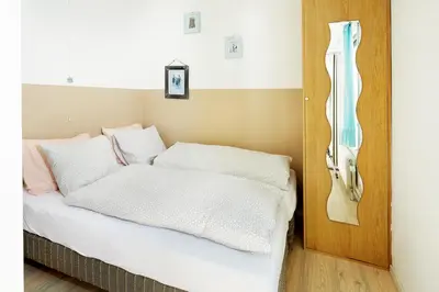 a bedroom with a bed with white sheets and a phone at Het Krekeltje in Zandvoort
