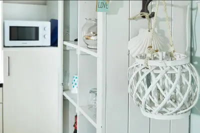 a room with a white shelf with a hanging basket at Het Krekeltje in Zandvoort