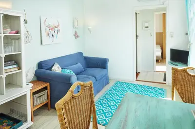 a living room with a blue couch and a table at Het Krekeltje in Zandvoort