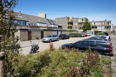 a motorcycle parked in a parking lot with parked cars at Het Krekeltje in Zandvoort