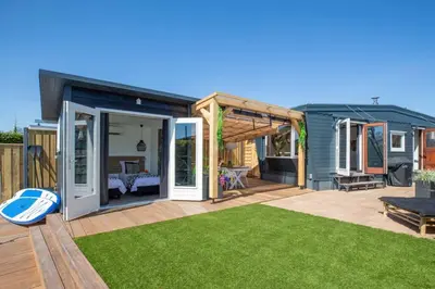 a small house with a deck and a lawn at Cabana incl boat, jacuzzi,subboarts on a quiet park with private parking in Loosdrecht