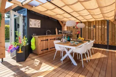 a kitchen and dining room with a table and chairs at Cabana incl boat, jacuzzi,subboarts on a quiet park with private parking in Loosdrecht
