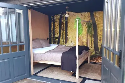a bedroom with a bed inside of a door at Bohemian included boat supboards and pool 5 minutes by boat from parking to the bohemien in Loosdrecht
