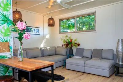a living room with couches and a table and flowers at Bohemian included boat supboards and pool 5 minutes by boat from parking to the bohemien in Loosdrecht