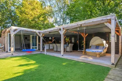 a pergola with a couch on a patio at Bohemian included boat supboards and pool 5 minutes by boat from parking to the bohemien in Loosdrecht