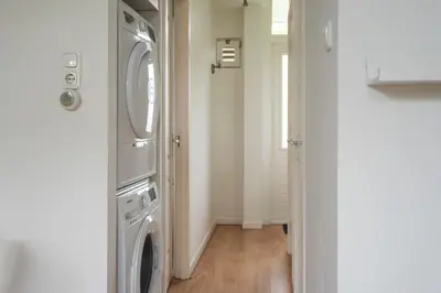 a laundry room with a washer and dryer at 't Schelpje with free parking in Zandvoort