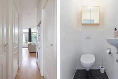 a white bathroom with a toilet and a sink at 't Schelpje with free parking in Zandvoort