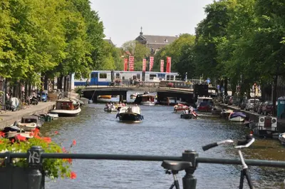 a river with boats in it with a bridge at Mozart Hotel in Amsterdam