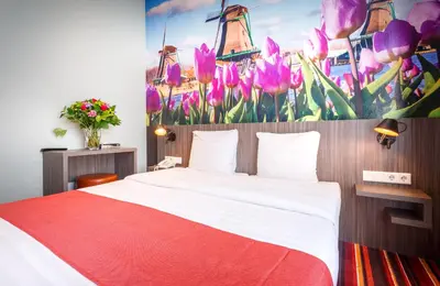 a bedroom with a bed and a painting of flowers at Mozart Hotel in Amsterdam