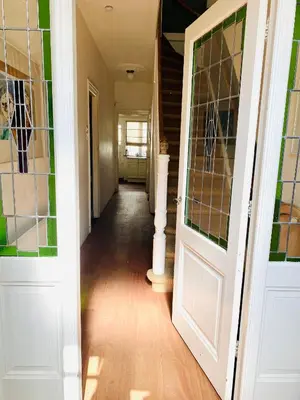 a hallway with two doors and aoyer with wood floors at Familiehuis aan zee met ruim dakterras in Zandvoort