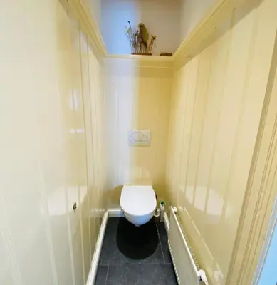 a small bathroom with a toilet in the corner at Familiehuis aan zee met ruim dakterras in Zandvoort