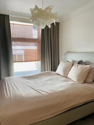 a bedroom with a large bed with a window at Familiehuis aan zee met ruim dakterras in Zandvoort