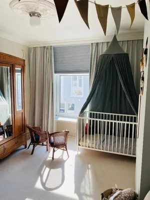 a baby room with a crib and a canopy at Familiehuis aan zee met ruim dakterras in Zandvoort